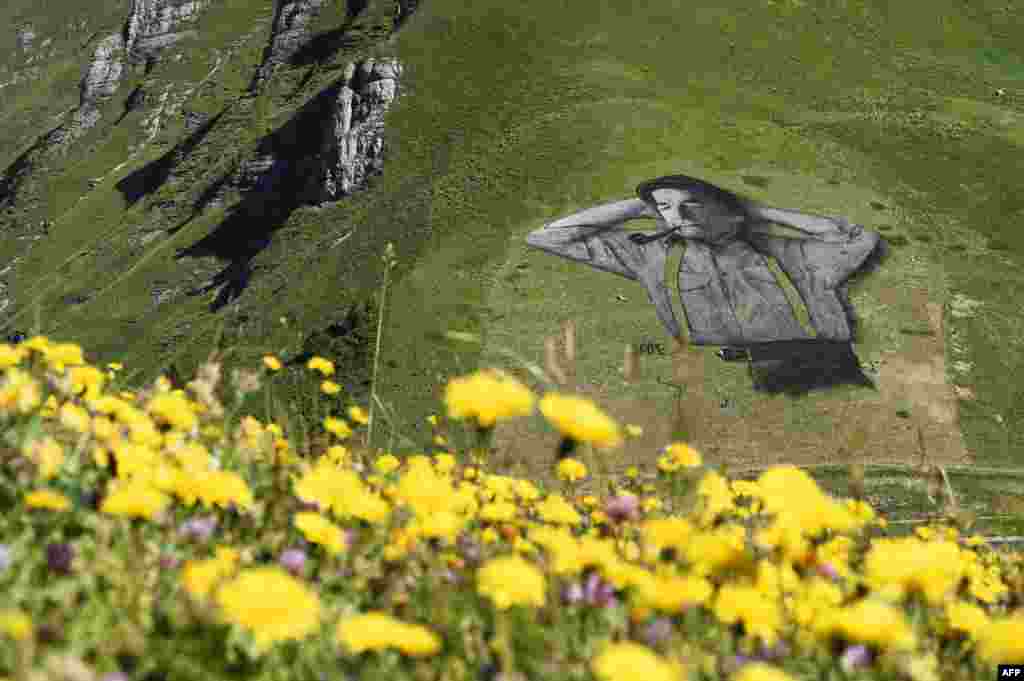 Lukisan &#39;ramah lingkungan&#39; karya pelukis Perancis Saype di lokasi ski Chaux-de-Mont, pegunungan Alpen, Swiss.