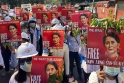 Para pengunjuk rasa memegang potret pemimpin Myanmar terguling Aung San Suu Kyi selama demonstrasi anti-kudeta di Mandalay, Myanmar pada 5 Maret 2021. (Foto: AP)