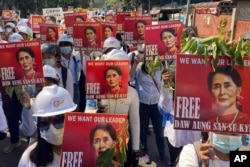 In this file photo, protesters hold portraits of ousted Myanmar leader Aung San Suu Kyi during an anti-coup demonstration in Mandalay, Myanmar on March 5, 2021. (AP Photo/File)