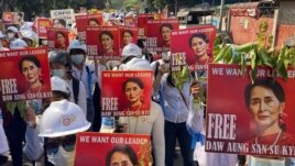 In this file photo, protesters hold portraits of ousted Myanmar leader Aung San Suu Kyi during an anti-coup demonstration in Mandalay, Myanmar on March 5, 2021. (AP Photo/File)
