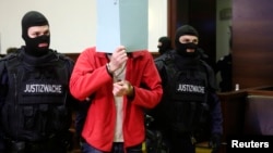 FILE - Defendant Magomed Z., a 30-year-old ethnic Chechen, is led into court for the start of his trial in Krems, Austria, Jan. 22. Austrian authorities accused him of fighting with IS militants in Syria in 2013.