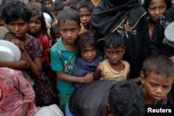 Rohingya refugees wait for food at Tengkhali camp near Cox's Bazar, Bangladesh, Dec. 8, 2017.