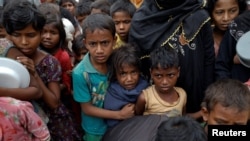 FILE - Rohingya refugees wait for food at Tengkhali camp near Cox's Bazar, Bangladesh, Dec. 8, 2017. 