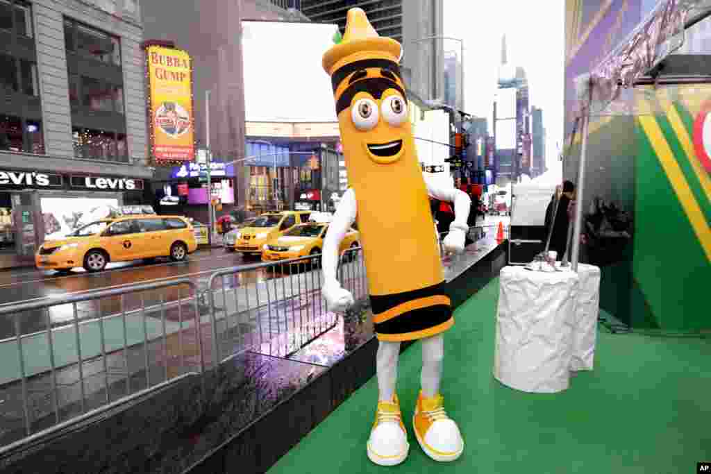 A dandelion crayon character poses for photos during a Crayola event in New York&#39;s Times Square. Crayola announced Friday, National Crayon Day, that it&#39;s replacing the color dandelion in its 24-pack with a crayon in &quot;the blue family.&quot;