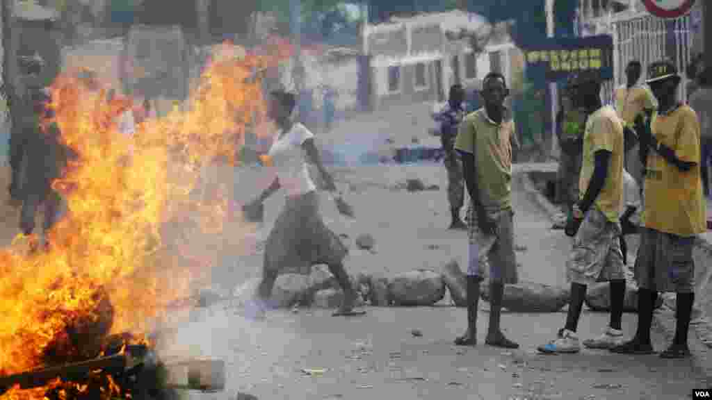 Des manifestants, débout,à côté d&#39;une barricade en flamme à Musaga, un quartier de Bujumbura, le 21 mai 2015.