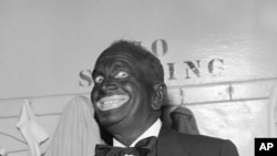 Al Jolson dons black-face makeup