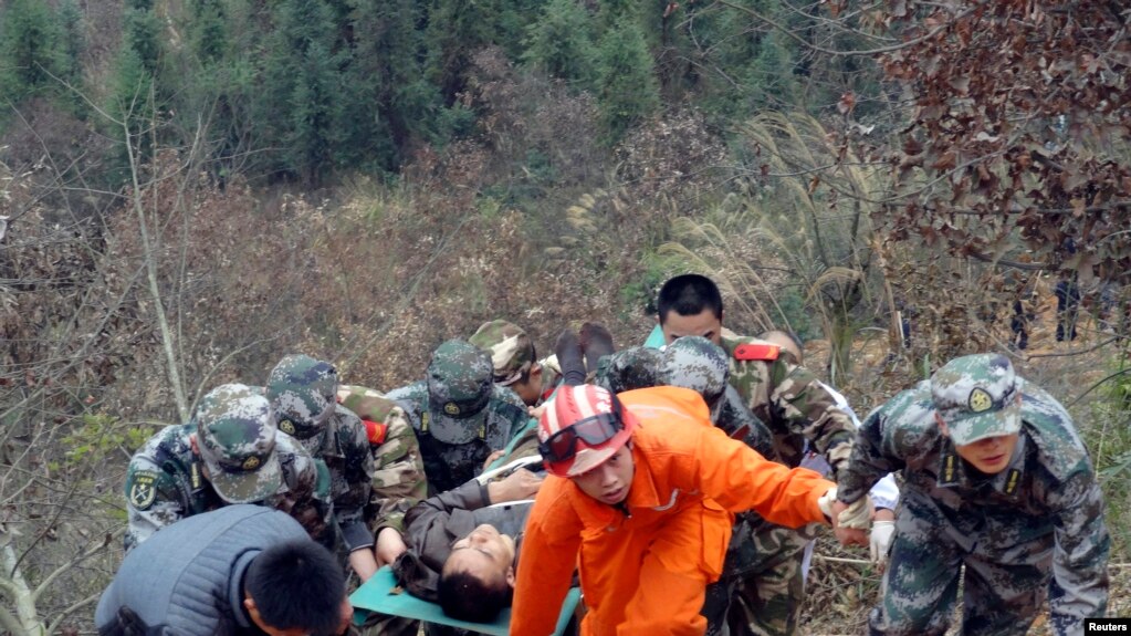 资料照片：2013年2月2日上午，在贵州省从江县，一辆超载的公共汽车坠入山谷后，救援人员用担架将一名男子抬上斜坡。这次事故造成13人死亡，21人受伤，其中11人严重受伤。(photo:VOA)