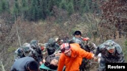 资料照片：2013年2月2日上午，在贵州省从江县，一辆超载的公共汽车坠入山谷后，救援人员用担架将一名男子抬上斜坡。这次事故造成13人死亡，21人受伤，其中11人严重受伤。