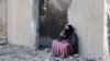 A woman talks on the phone as Syrians flee their homes in the Ghwayran neighbourhood in the northern city of Hasakeh on Jan. 22, 2022.