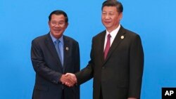 PM Kamboja Hun Sen (kiri) dan Presiden China Xi Jinping berjabat tangan dalam pertemuan di Beijing, China Mei tahun lalu (foto: dok). 