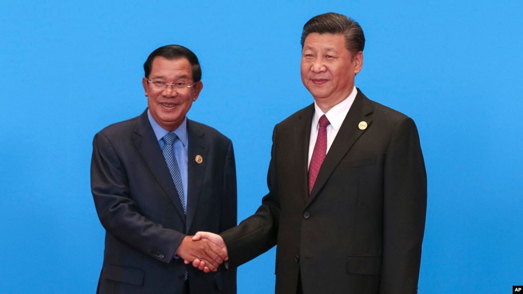 Cambodian Prime Minister Hun Sen, left, and Chinese President Xi Jinping, right, shake hands during the welcome ceremony for the Belt and Road Forum, at the International Conference Center at Yanqi Lake in Beijing, Monday, May 15, 2017. (Roman Pilipey/Pool Photo via AP)