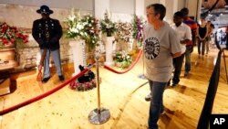 Friends and fans file past flowers and his famed guitar "Lucille," on their way to B.B. King's coffin during a public viewing, May 29, 2015, in the B.B. King Museum and Delta Interpretive Center in Indianola, Mississippi.