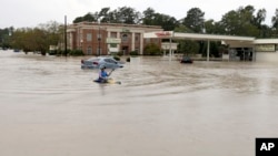  Jordan Bennett, of Rock Hill, S.C., paddles down a flooded a street in Columbia, S.C., Sunday, Oct. 4, 2015.