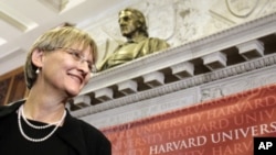 Harvard University President Drew Gilpin Faust stands beneath a bust of the founder of the university, John Harvard
