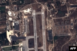 FILE - This handout image taken by EADS' Astrium Press on September 20, 2015, by Pleiades Satellite purports to show a view of Russian fighter jets and helicopters at a military base in Latakia, Syria.