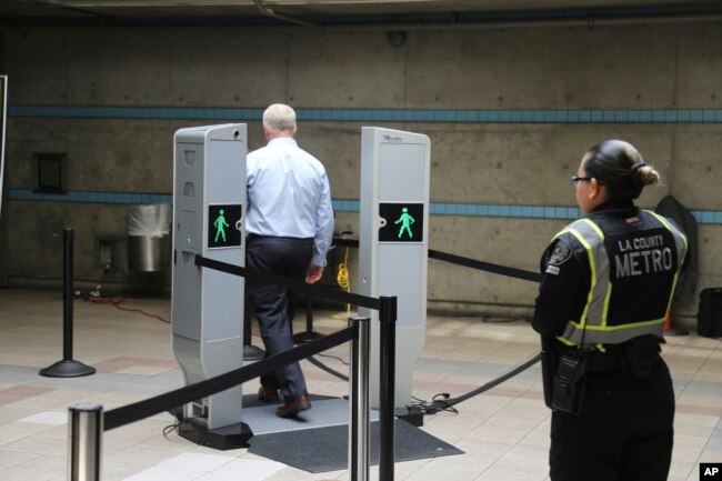 FILE - Chris McLaughlin, a vice president with Evolv Technology, test the company's body scanner at Union Station subway station in Los Angeles Wednesday, Aug. 16, 2017. (AP Photo/Mike Balsamo)