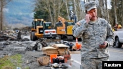 Un oficial de la Guardia nacional coordina con el comando de operaciones sobre la búsqueda de sobrevivientes o cadáveres en Oso, estado de Washington.