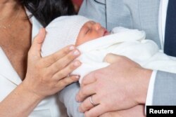 Los orgullosos padres se mostraron sonrientes mientras presentaban al bebé ante un pequeño grupo de periodistas.