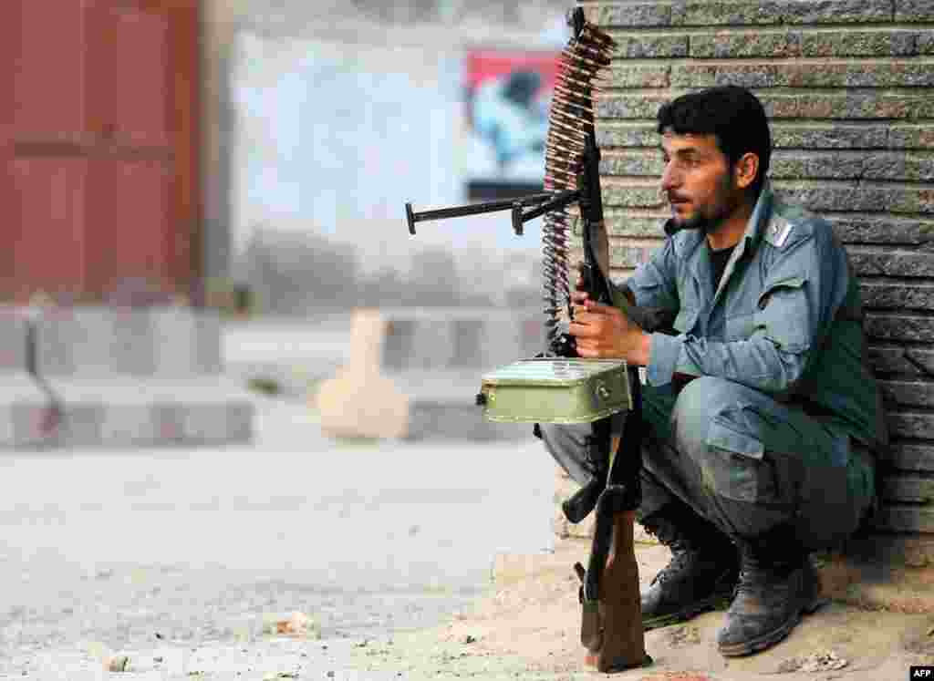 An Afghan policeman keeps guard at the site of an attack in Kabul April 15, 2012. (Reuters)