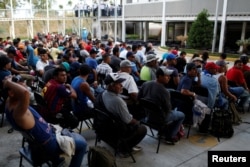 Migrants from Honduras, part of a new caravan from Central America trying to reach the United States, wait to be processed in an immigration facility in Ciudad Hidalgo, Mexico, Jan. 17, 2019.