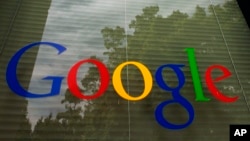 FILE - The Google logo on a window at the company's headquarters in Mountain View, Calif. 