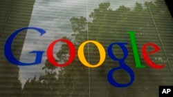 FILE - The Google logo is seen on a window at the company's headquarters in Mountain View, California. 