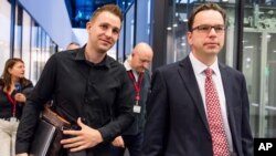 Max Schrems, left, who took his complaint about the Safe Harbor pact to the European Court of Justice, and his lawyer, Herwig Hofmann, walk in the hallway after the ruling in Luxembourg, Oct. 6, 2015.