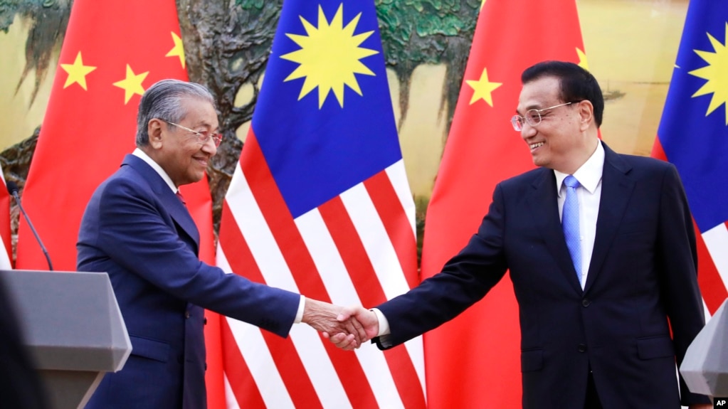 Thủ Tướng Malaysia Mahathir Mohamad, trái, bắt tay vị tương nhiệm TQ Lý Khắc Cường vào lúc kết thúc cuộc họp báo tại Đại Sảnh đường Nhân dân ở Bắc Kinh, ngày 20/8/2018. (How Hwee Young/Pool Photo via AP)