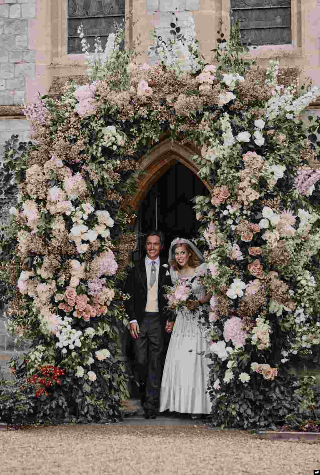 In this photograph released by the Royal Communications of Princess Beatrice and Edoardo Mapelli Mozzi, Britain&#39;s Princess Beatrice and Edoardo Mapelli Mozzi stand in the doorway of The Royal Chapel of All Saints at Royal Lodge, Windsor, England, after their wedding, July 18, 2020. Princess Beatrice wore a vintage dress loaned to her by Queen Elizabeth II at her wedding, Buckingham Palace said.