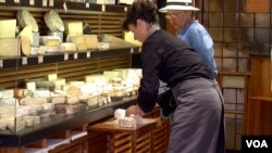 Wrapping up cheese at Androuet, one of France's leading cheese stores. (L. Bryant/VOA)