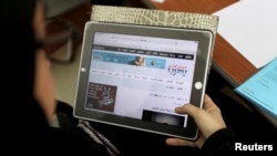 FILE - A Saudi woman explores a website on her tablet in Riyadh.
