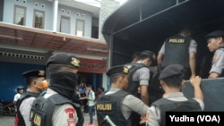 Polisi bersenjata lengkap di depan lokasi penggeledahan tempat kerja terduga teroris yang ditangkap Densus Anti-teror di Sukoharjo (Foto: VOA/Yudha)