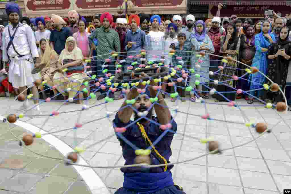 A Sikh devotee demonstrates his &#39;Gatka&#39; traditional martial art skills during the &#39;Nagar Kirtan&#39; procession marking the 550th birth anniversary of Guru Nanak Dev, the founder of Sikhism, at the Golden Temple in Amritsar, India.