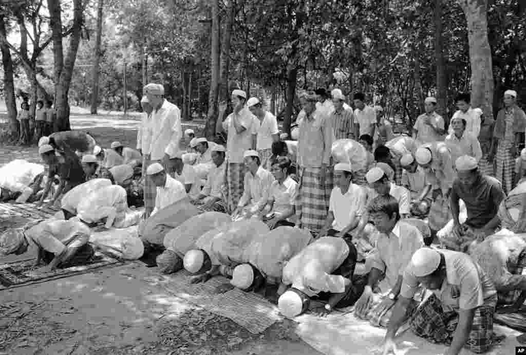 Cambodian Muslim men give thanks to Allah for deliverance in Aranyaprathet, Eastern Thailand on April 25, 1975, after fleeing across the border from Cambodia. Muslim refugees, members of the Cham Ethnic Minority, told newsmen about 30 of their number were killed by Khmer Rouge troops before about 400 got through on Thursday. (AP Photo/LAY)