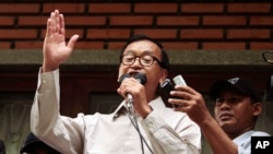 President of National Rescue Party Sam Rainsy, center, gives a speech during a public forum at their party's office in Phnom Penh, Cambodia, July 31, 2013. 