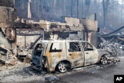 A scorched vehicle sits next to a burned-out building in Gatlinburg, Tennessee, Nov. 29, 2016.