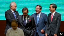 Leaders of Association of Southeast Asian Nations (ASEAN) from left, Malaysian Prime Minister Najib Razak, Sultan of Brunei Hassanal Bolkiah, Cambodian Prime Minister Hun Sen, and Indonesian President Joko Widodo walk back to their seats after posing for a group photo during the opening ceremony of the 25th ASEAN summit at Myanmar International Convention Center in Naypyitaw, Myanmar, Wednesday, Nov. 12, 2014.(AP Photo/Gemunu Amarasinghe)