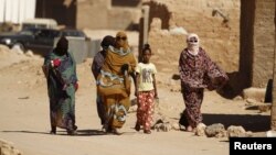 Indigenous Sahrawi women walk through Al Smara desert refugee camp in Tindouf, southern Algeria, March 4, 2016. 