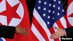 FILE - U.S. President Donald Trump and North Korea's leader Kim Jong Un meet at the start of their summit on the resort island of Sentosa, Singapore, June 12, 2018. 