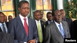 File - Zimbabwe President Robert Mugabe (R) and his Zambian counterpart Edgar Lungu step out of State House in Harare, February 2015.