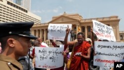 FILE - Protesters in Sri Lanka denounce the government's decision to issue death certificates for persons gone missing during country's civil war, in Colombo, Feb. 11, 2020. The placards read "Who killed the disappeared?" in Tamil and Sinhalese.