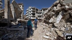 Syrian children walk between destroyed buildings in the old city of Homs, Syria, Feb. 26, 2016. 