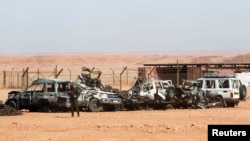 Algerian soldier stands near damaged cars used by Islamist militants during siege near the Tiguentourine Gas Plant, In Amenas, Jan. 31, 2013.
