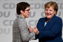 FILE - Annegret Kramp-Karrenbauer is embraced by German Chancellor Angela Merkel after being elected as the party leader during the Christian Democratic Union (CDU) party congress in Hamburg, Germany, Dec. 7, 2018.