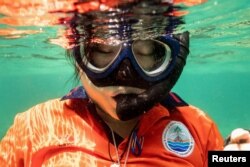 Metavee Chuangcharoendee, 27, from the Maya Shark Watch Project, and who is also a marine biologist with the Department of Marine and Coastal Resources of Thailand, pauses while snorkelling as she removes pieces of abandoned fishing nets from a coral reef in Maya Bay, at the Phi Phi Island National Park, on Phi Phi Leh Island, Krabi province, Thailand February 26, 2023.