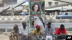 Wasu 'yan Nigeriake nan zaune a karkashin gada dauke da takardun gangamin zabe na Fasta a Ojuelegba jihar Ikkon Nigeria.