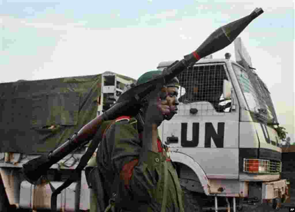 FILE - In this Nov. 23, 2008 file photo, a Congolese government soldier (FARDC) stands guard by a UN truck at the Kibati checkpoint north of Goma, eastern Congo. U.N. peacekeepers deployed to Congo more than a decade ago after civil war drew in troops fro