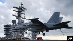 FILE - A F18 Super Hornet prepares to land on the deck of the USS Eisenhower off the coast of Virginia, December 10, 2015 in the Atlantic Ocean. 