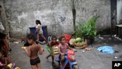 Niños juegan en un edificio ocupado que solía albergar una fábrica, en medio de la pandemia de coronavirus, en Río de Janeiro, Brasil, el miércoles 13 de enero de 2021.