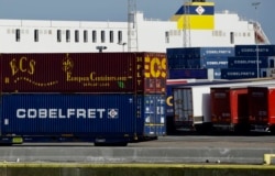 Truck trailers are parked among stacked cargo containers as British police investigate the deaths of 39 people found in a truck container they believe came from Zeebrugge, Belgium, Oct. 24, 2019.